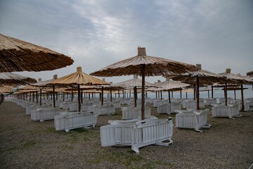 chairs and beach umbrellas at an empty sand beach at Lake Ohrid