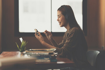 Young composer woman recording music lyrics her voice in to smartphone.