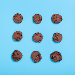 Chocolate and white cookies on a blue background. Top view, flat lay.