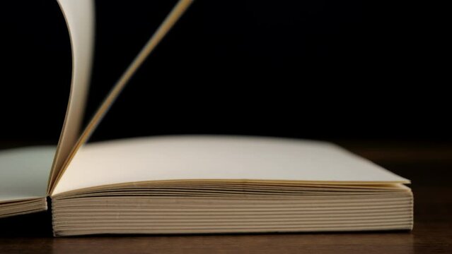 4K-Slow motion of open book with blank page on black background, Education and business concept.