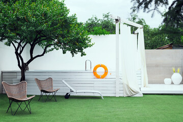  Fenced yard with a beautiful white pool and a green lawn with chairs and sunbeds