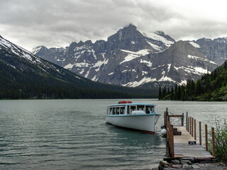 Majestic mountains and lake with boat coming to dock