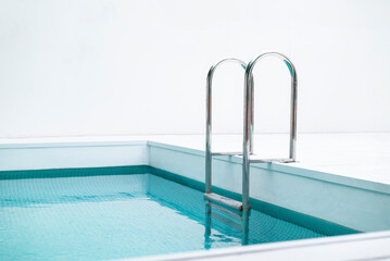 Ladder stainless handrails for descent into swimming pool. Swimming pool with handrail . Ladder of...