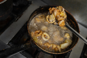 Pan with meat and breaded squid frying