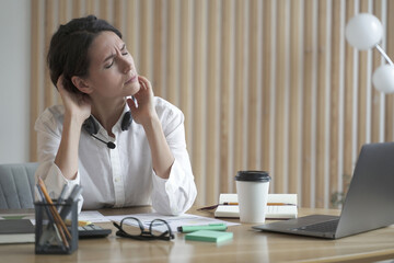 Overworking remote call center operator lady suffers from fatigue and neck pain