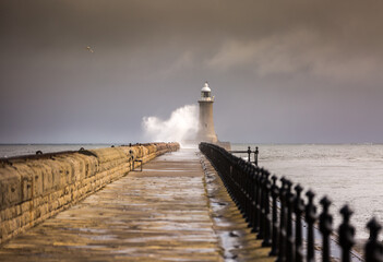 Fototapeta na wymiar Tynemouth Pier and the Lighthouse guarding the mouth of the River Tyne on a cloudy day