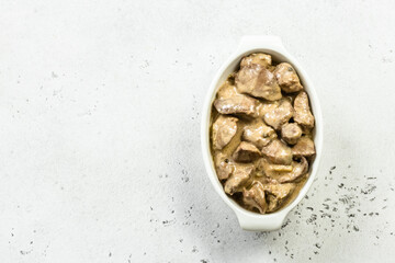 Chicken stroganoff in ceramic dish. Top view, copy space, flat lay.