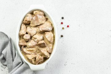 Lemon garlic liver, cream sauce in ceramic dish. Top view, copy space, flat lay.