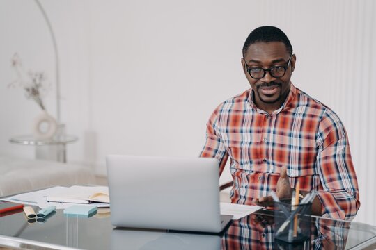 Puzzled african american man look at laptop screen. Poor internet connection. Problem at remote work