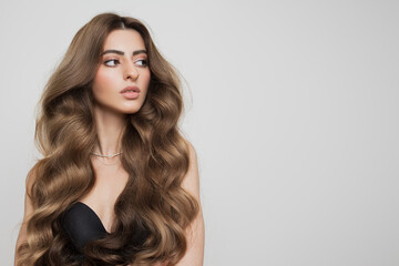 Portrait of a beautiful girl with luxurious curly long hair. White background.