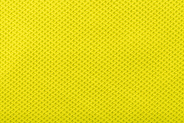 The texture of the fabric is yellow with straight lines, rhombuses. Background of fabric for tailoring sportswear