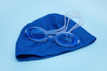 swimming cap, goggles on a blue background.