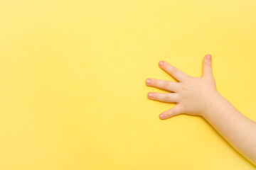 children's palm on a yellow background with copy space