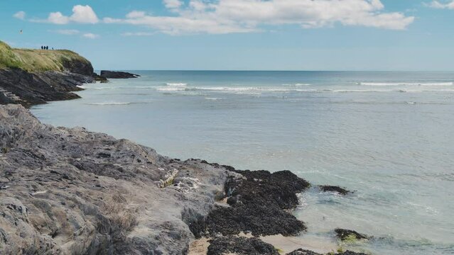 Rocky seashore on a sunny day. Blue ocean waters. Seaside landscape. Hand-held video, 4k resolution.