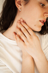 Sick attractive girl touches throat with pain. Laryngitis first symptoms throat ache. Seasonal illness medecine.