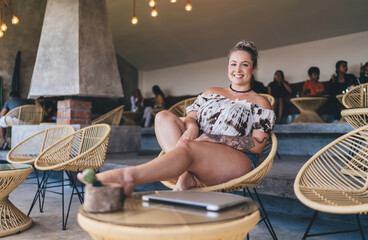 Carefree Swedish woman sitting front open laptop computer while working remote on freelance....