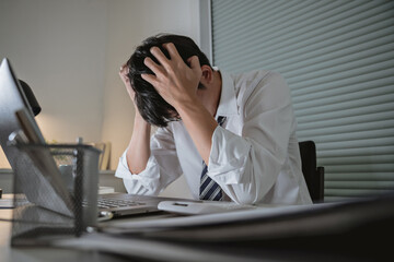 Asian stress business man tired and worried in office at late night.