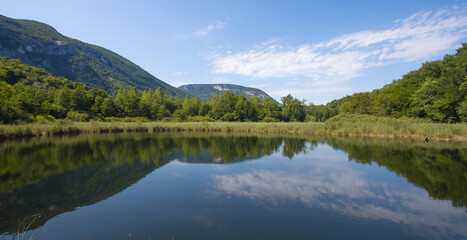 Fototapeta na wymiar Vue sur le lac de Virieu en été. C'est un lac à Virieu-le-Grand dans le département de l'Ain en France.