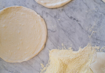 background of pizza dough ready to be baked on marble top , photo with copy space