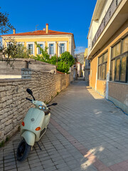 Scooter on a narrow street in Greece. Narrow and beautiful streets in Greece. facades of colorful...
