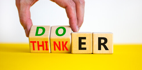 Doer or thinker symbol. Concept words Doer or thinker on wooden cubes. Businessman hand. Beautiful yellow table white background. Business and doer or thinker concept. Copy space.