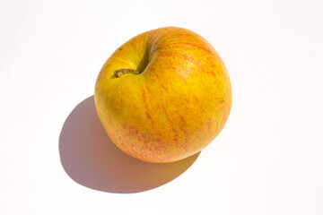yellow organic apple lies on a white background
