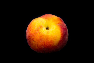 a juicy peach lies on a black background