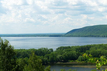 lake and mountains in the summer.beautiful view from the top of the mountain. cloud sky over green hills with blue river