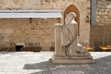 Statue of praying monk in Hvar town on Hvar island, Croatia