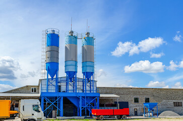 Paving plant. Industrial building with big blue tanks for cement, sand, water.  Panoramic photo.