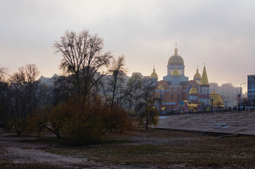 Scenic autumn landscape of Obolon neighborhood. Church in thick fog in the background. Romantic and peaceful scene