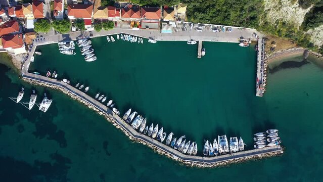 Small marina with catamaran yachts and sailboats in Greece. Kalamos Marina. Beautiful and cozy harbor in Greece. Old fishing village with port on the shore of the Ionian Sea. Travel by boat on the sea