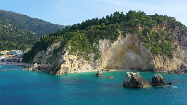 Beach in Lefkas Petra Greece, Milos Hidden Beach. The holiday village of Agios Nikitas behind the cliffs of the seafront. Cliff with vegetation and rocks on the shore of the Ionian Sea. Exotic beach.