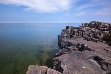Fototapeta na wymiar A Smooth Lake Superior with a rocky shore.