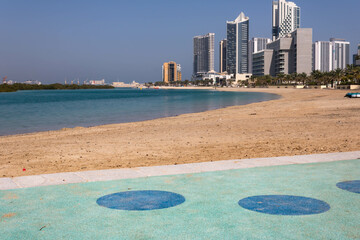 Beach walk at Al Reem island in Abu Dhabi, modern skyscrapers in the background