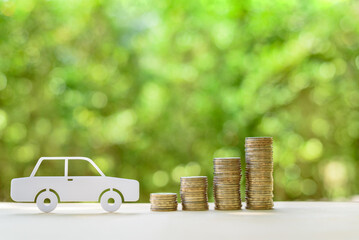 Used and second hand vehicle / car or auto loan, financial concept : Sedan car and rows of coins on a table, depicts money loan or borrowing fund to buy a new or old car for personal or individual use - obrazy, fototapety, plakaty