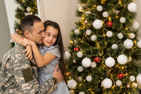 Soldier In Uniform With His Daughter. An Off Duty Military Man Spending Christmas Holiday With His Family At Home.