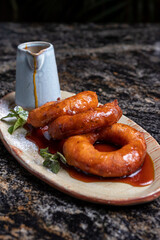 Postre peruano, picarones con jarabe de miel