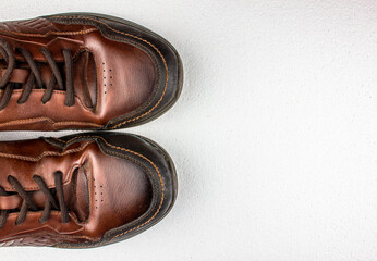 Brown leather men's shoes pair. Brown low shoes, men's sneakers top view on a white background.