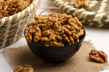 walnut served in a bowl isolated on napkin side view of nuts on grey background