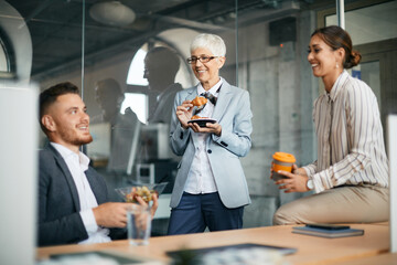 Group of happy coworkers communicating on break in the office.