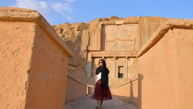 Persepolis, Iran - 8th june, 2022: tourist walk by scenic carved rocks in Persepolis archeological site. Persian city remains and history concept