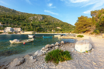 Picturesque bay with moored boats, beautiful blue sea and green trees growing on the hill in the...