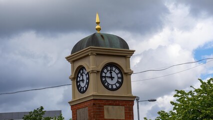 A clock tower with a gilded dome top