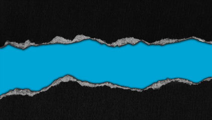 Ripped black paper on blue background, space for copy