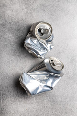 Empty crumpled can on gray table.