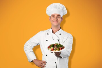 Young man standing and holding plate or dish on the background