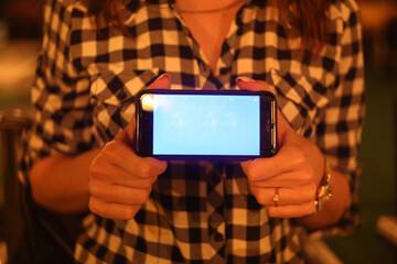 holds an expensive phone in his hands with a manicure and jewelry