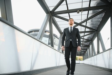 Handsome male model posing wearing a back suit.