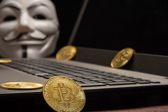 Araras, Sao Paulo, Brazil. July 04, 2022. Bitcoin, laptop, mask used by hacker and various bitcoins, low key style photo, selective focus.